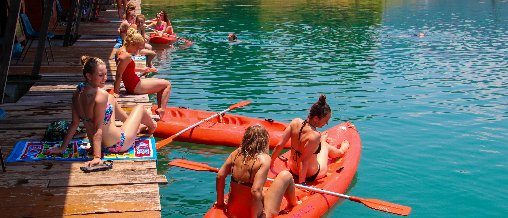 Travelers enjoy kayaking and swimming from floating bungalows on the clear waters of Khao Sok.