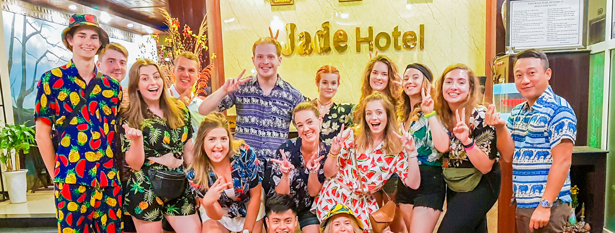 A joyful group of young travelers smiling and posing for a photo at Jade Hotel.