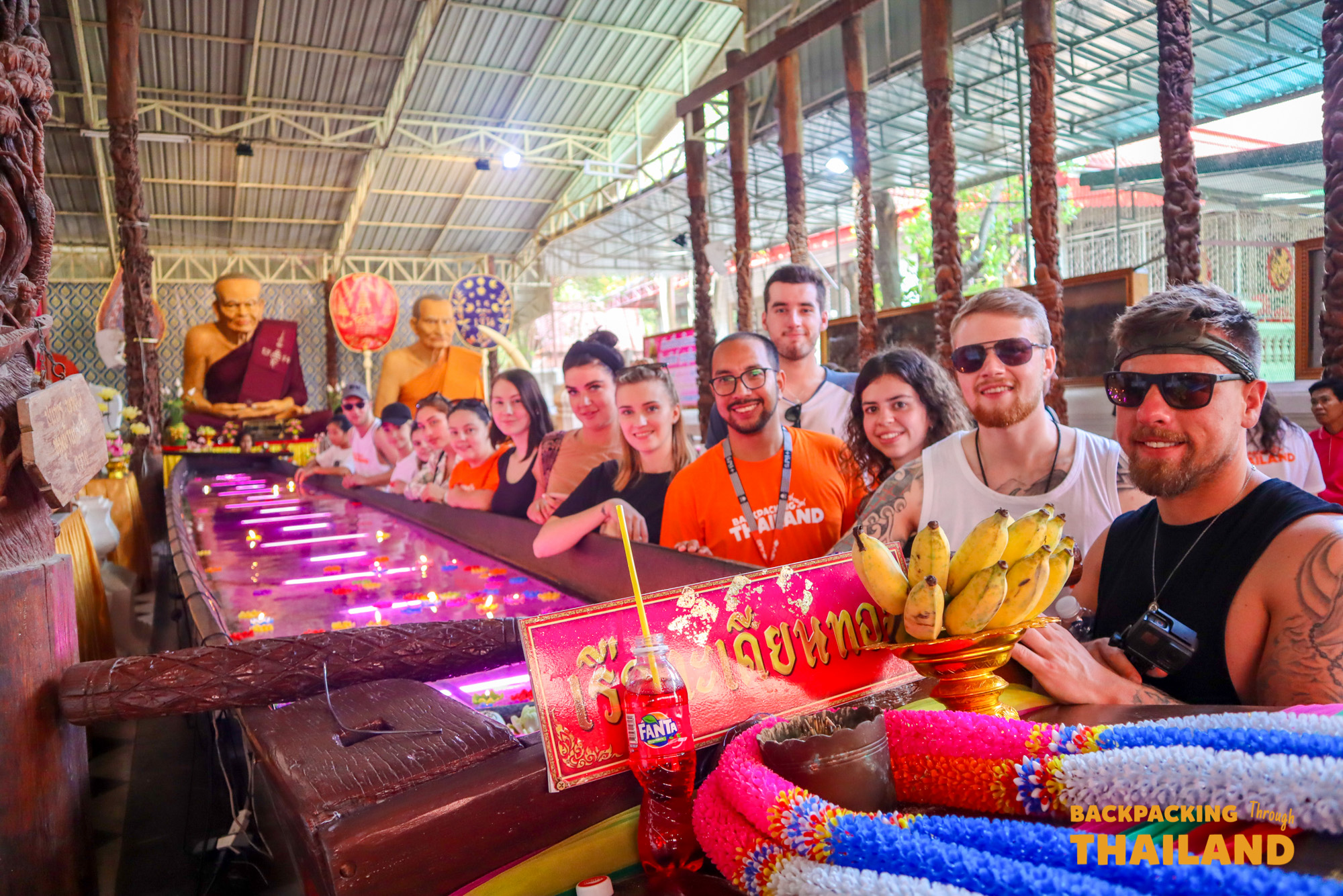 A group of backpackers inside an ornately decorated Thai temple