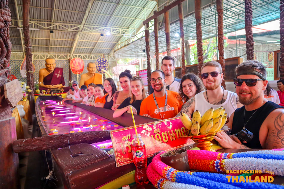 A group of backpackers inside an ornately decorated Thai temple
