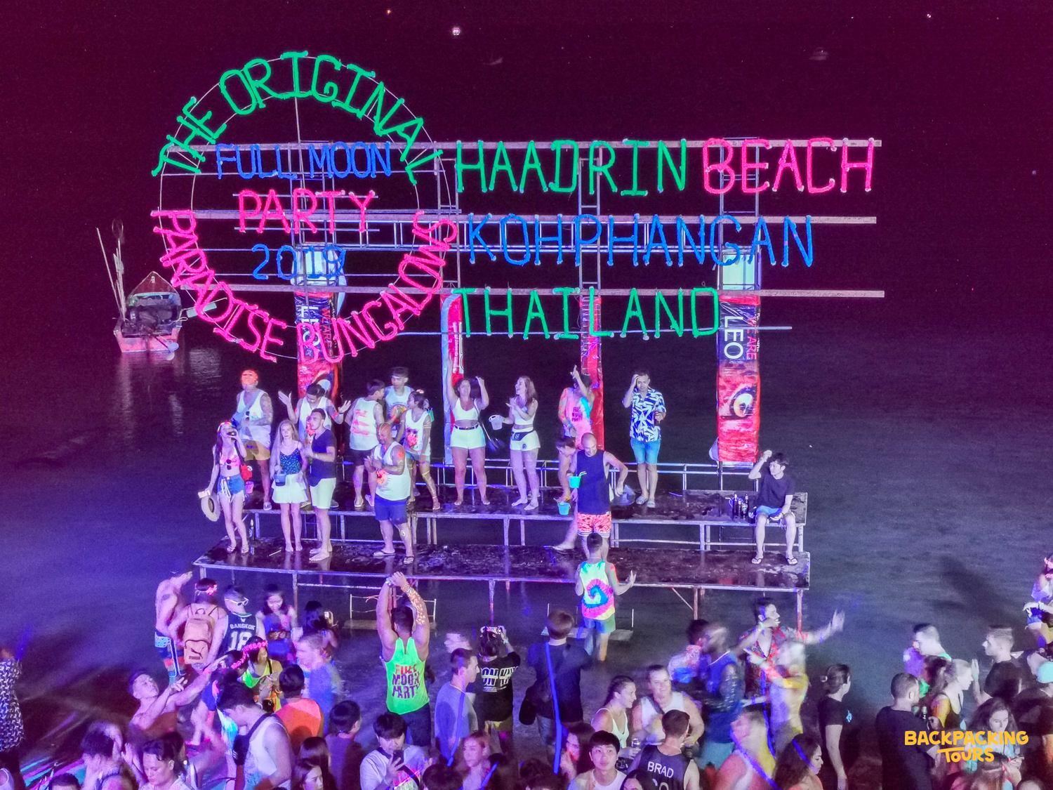 Crowds dancing under neon lights at the Full Moon Party on Haad Rin beach, Koh Phangan