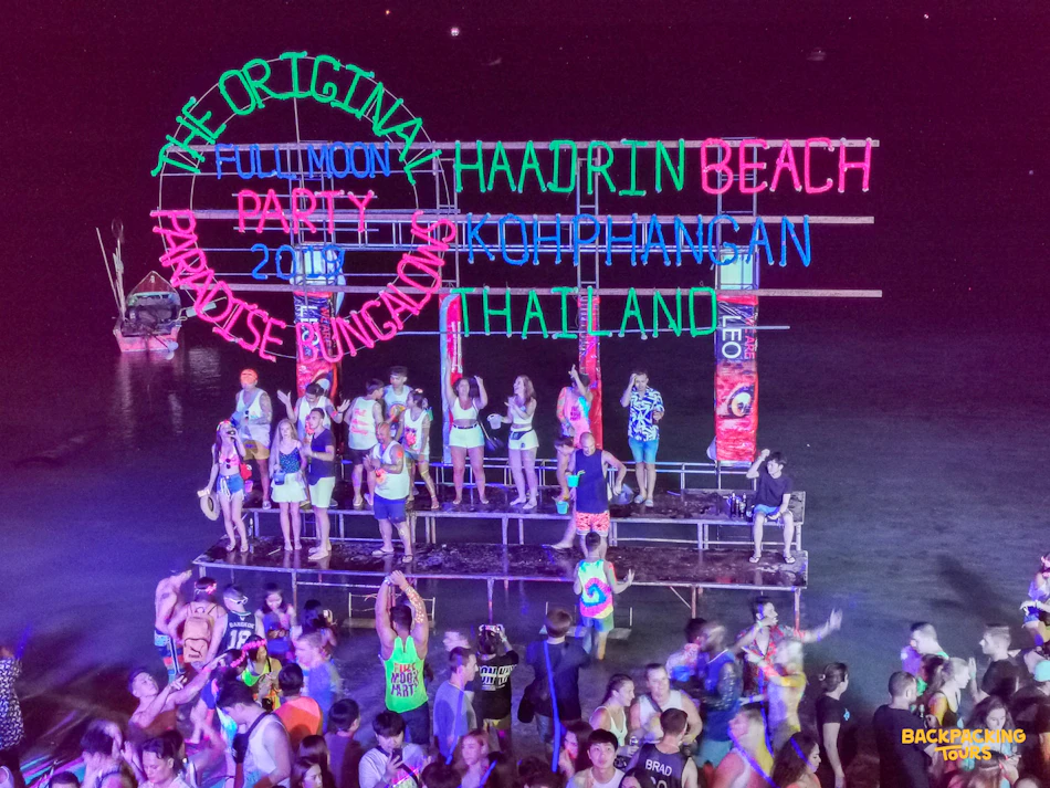 Crowds dancing under neon lights at the Full Moon Party on Haad Rin beach, Koh Phangan