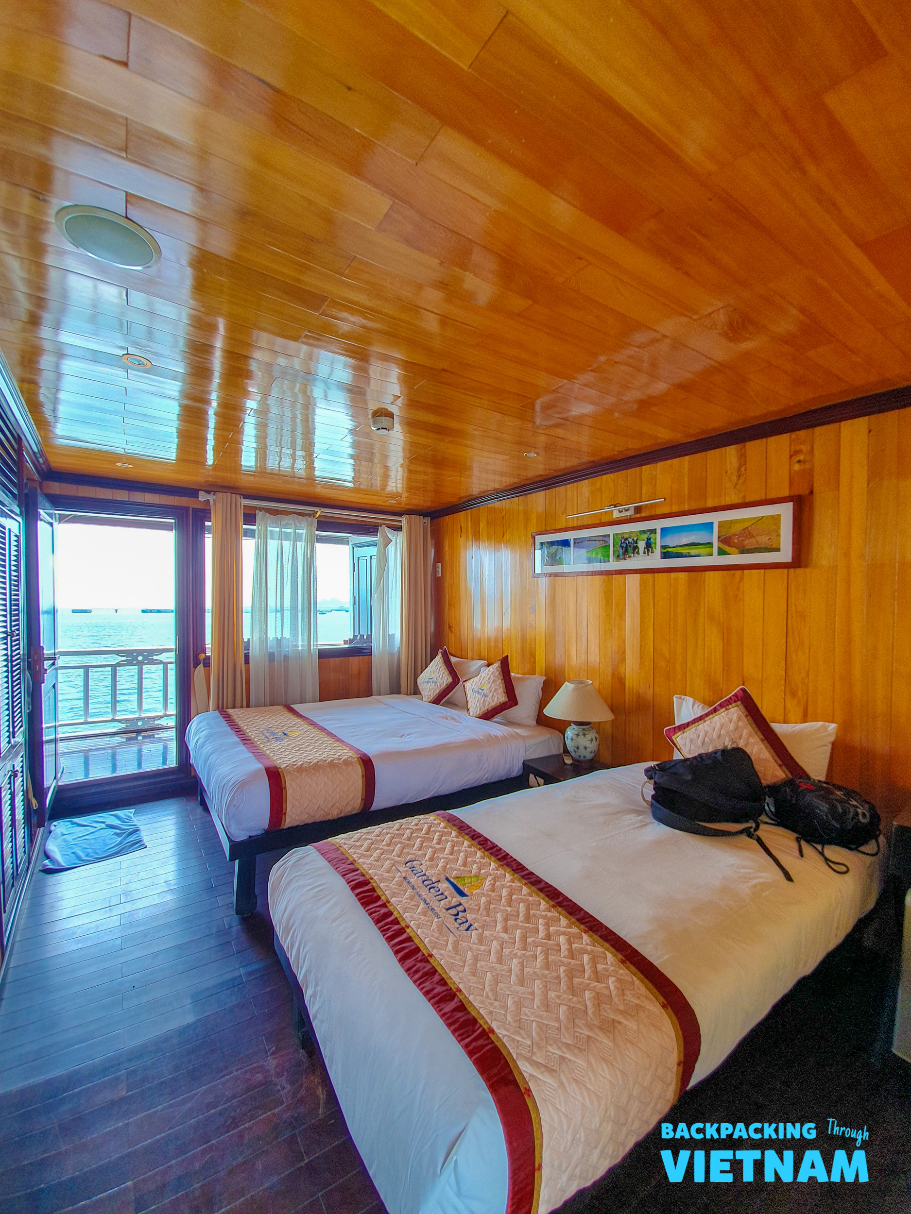 A comfortable twin cabin on a wooden sleeper boat, with a private balcony overlooking Halong Bay.