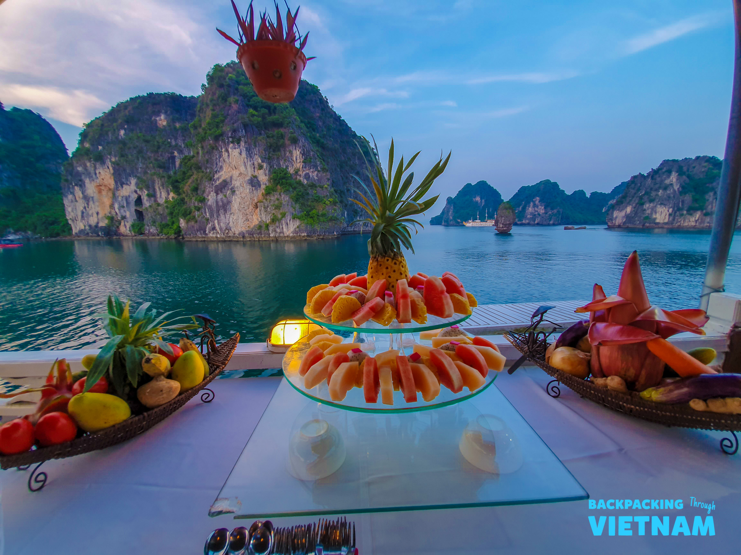 Enjoying a delicious fruit spread on a cruise boat, surrounded by the breathtaking scenery of Halong Bay.