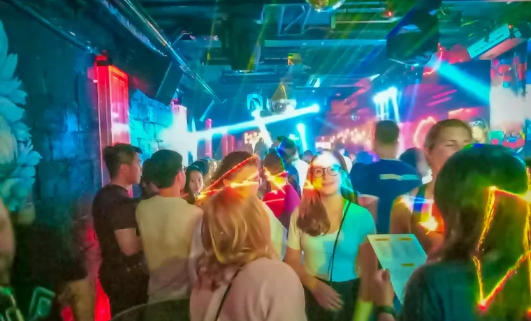 Young backpackers enjoy a lively night out dancing and socializing in a vibrant club in Hanoi.
