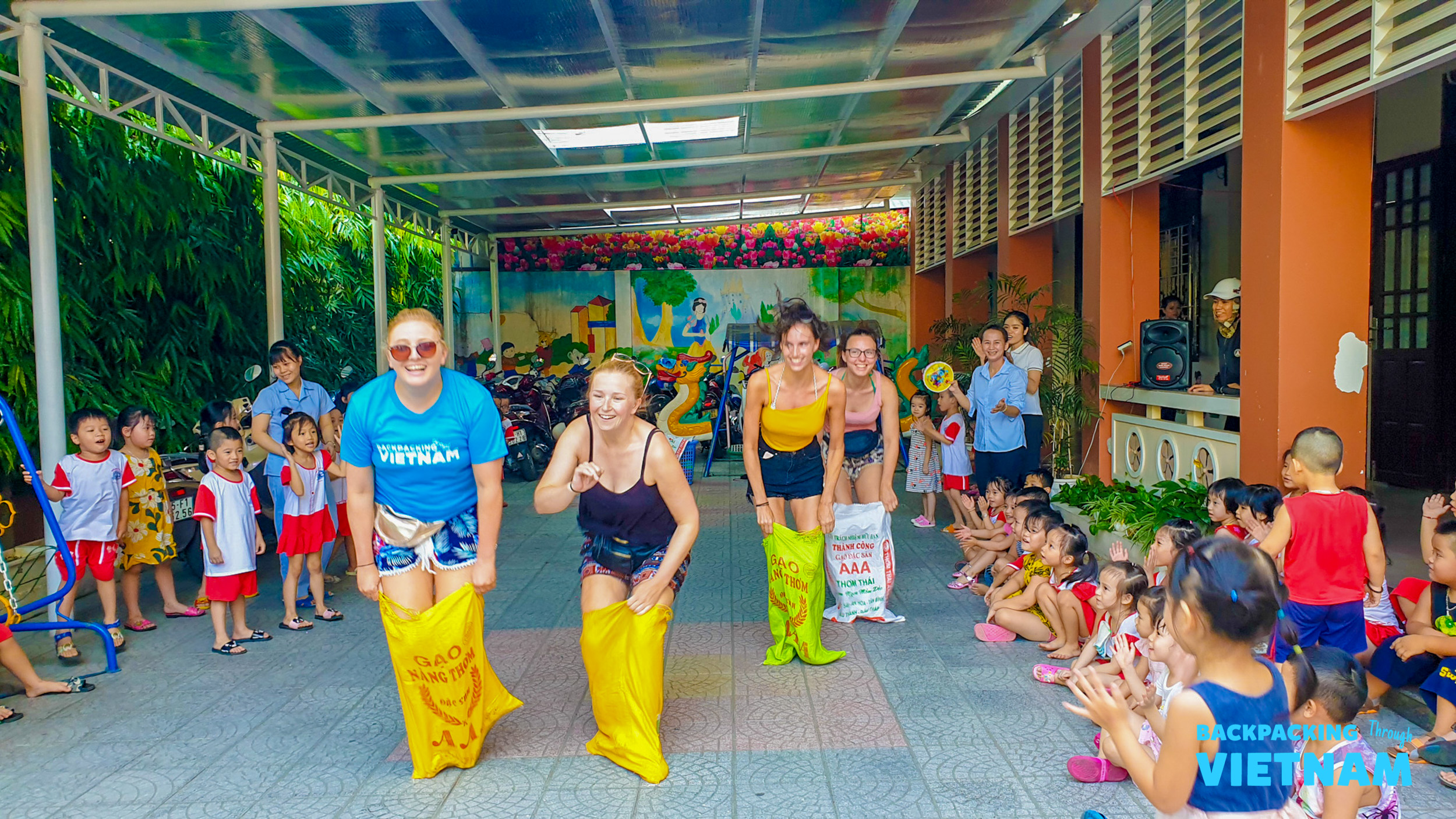 Volunteers and children participate in a joyful sack race at a school in Hue, Vietnam.