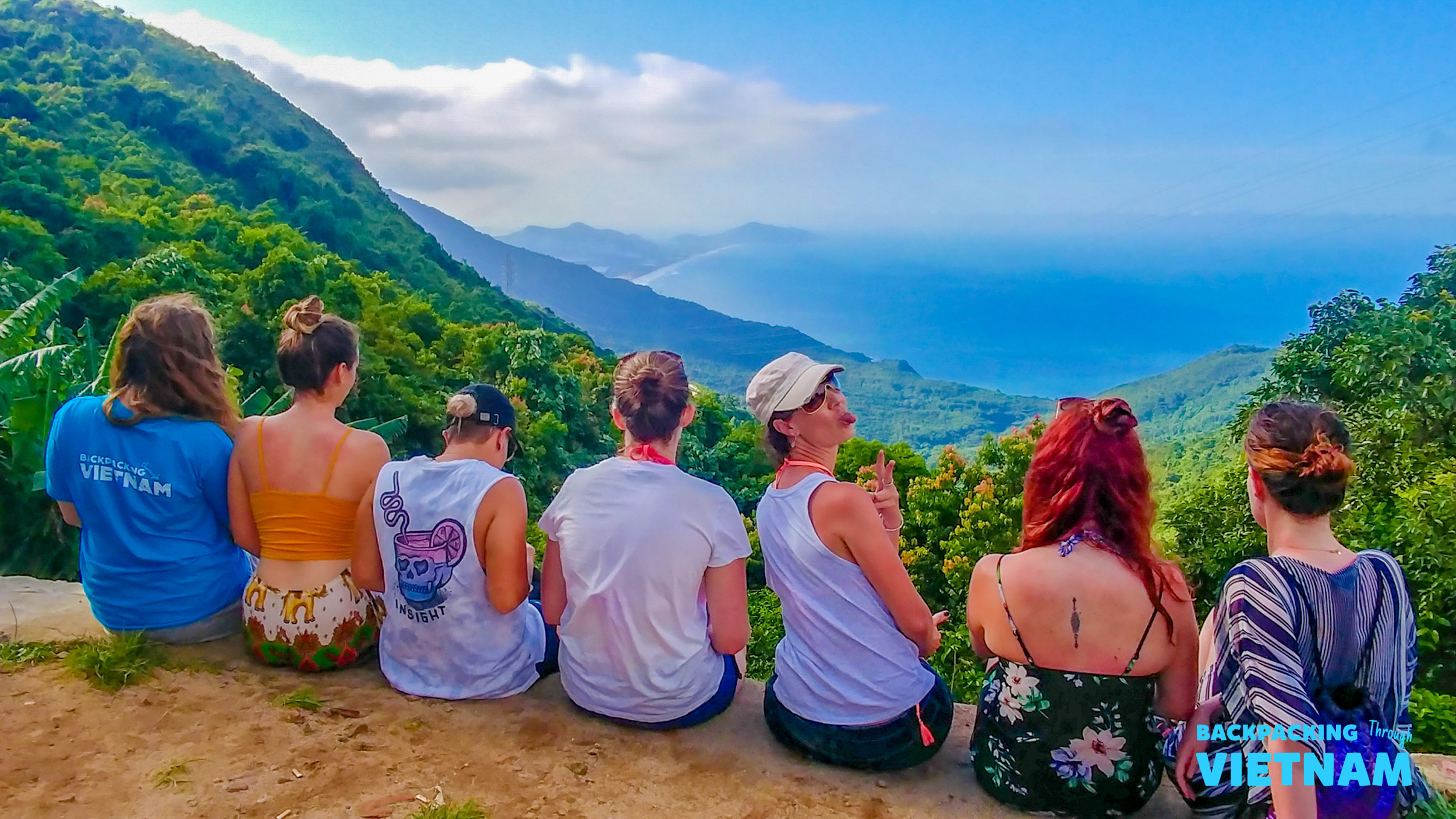 Backpackers pause at Hai Van Pass, enjoying the spectacular views of Vietnam's coastline and ocean.