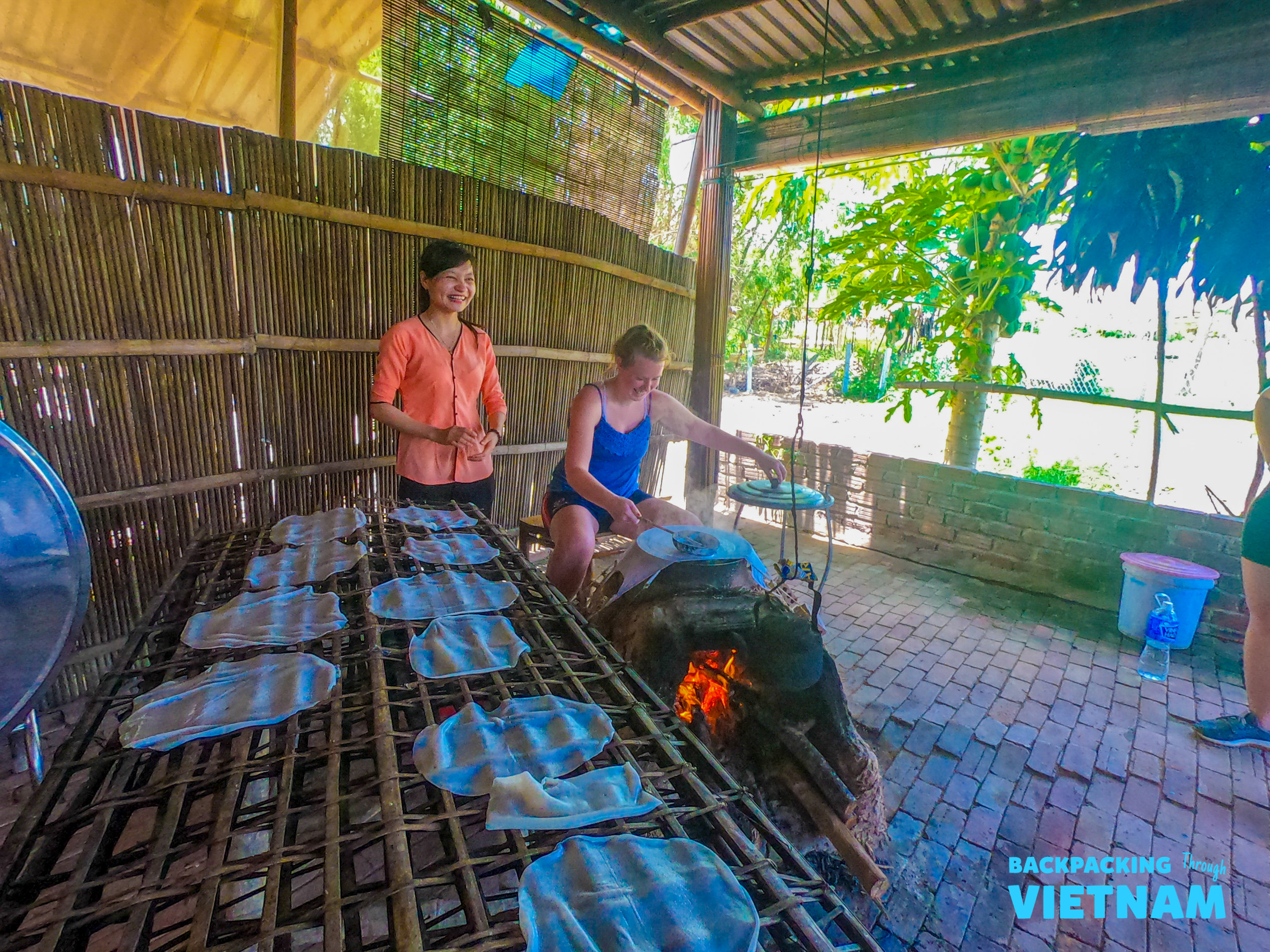 A tourist learns to make rice paper from scratch with a local farmer in Hoi An, Vietnam.