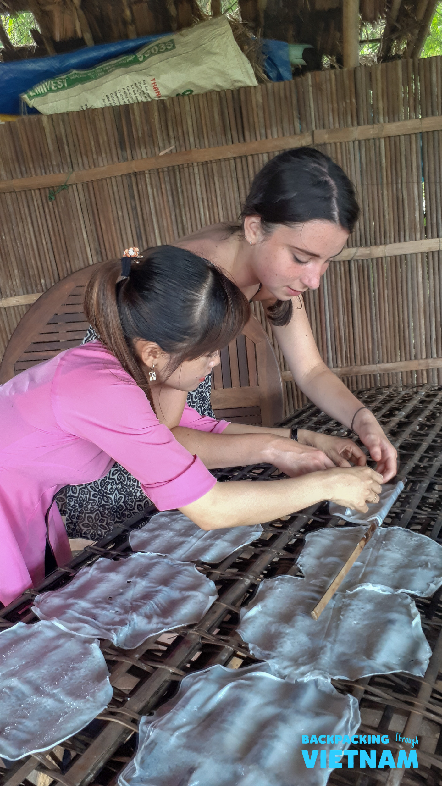 Two women learn to make traditional rice paper from scratch in Hoi An, Vietnam.