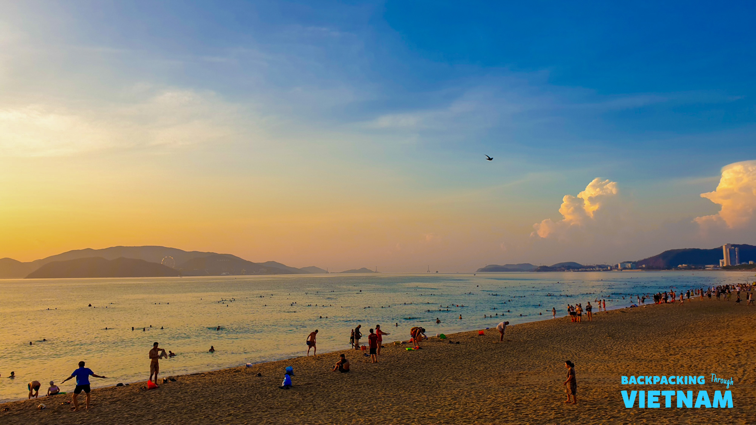 Beachgoers enjoy the warm glow of sunset over the ocean in Nha Trang, Vietnam.