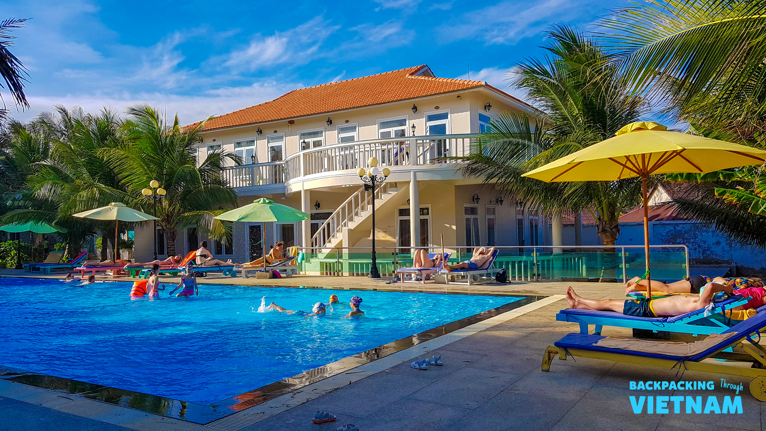Guests enjoy swimming and sunbathing by the inviting pool at a Mui Ne beachfront resort.