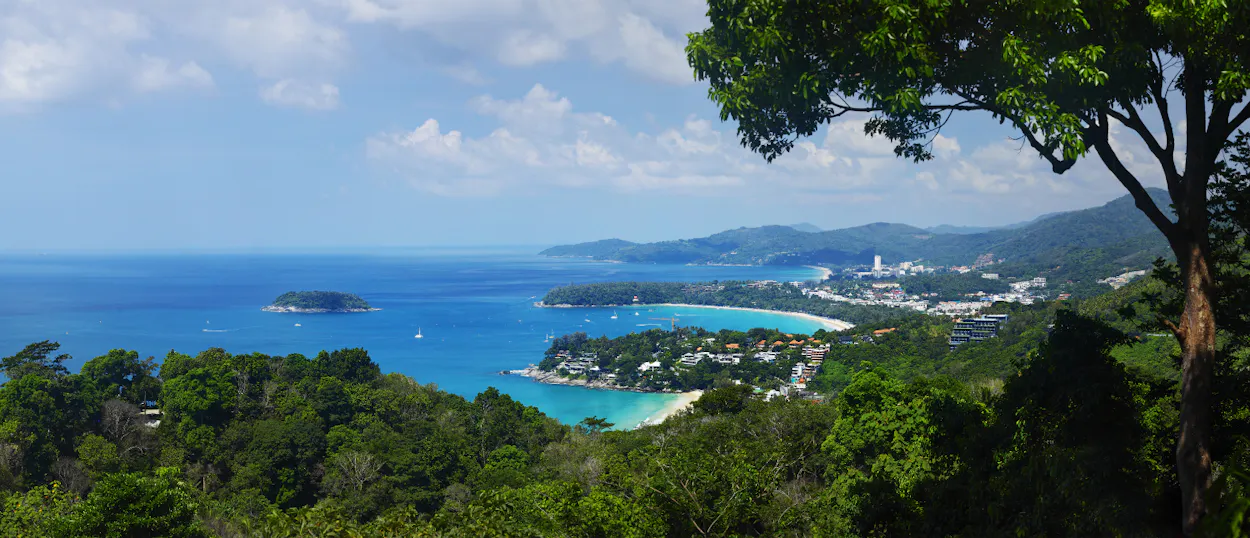 Stunning panoramic view of turquoise bays, white sand beaches, and lush green hills in Phuket.