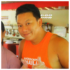 A smiling man in an orange "Backpacking Thailand" tank top, holding food.