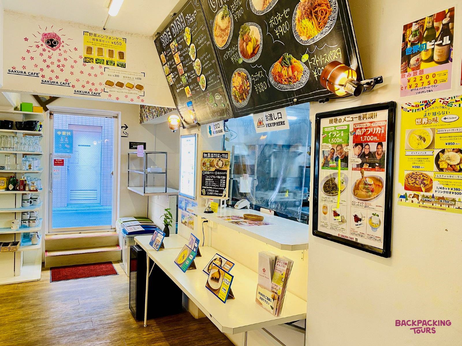 A brightly lit, inviting cafe in Tokyo with a counter, menu boards, and delicious-looking Japanese dishes.