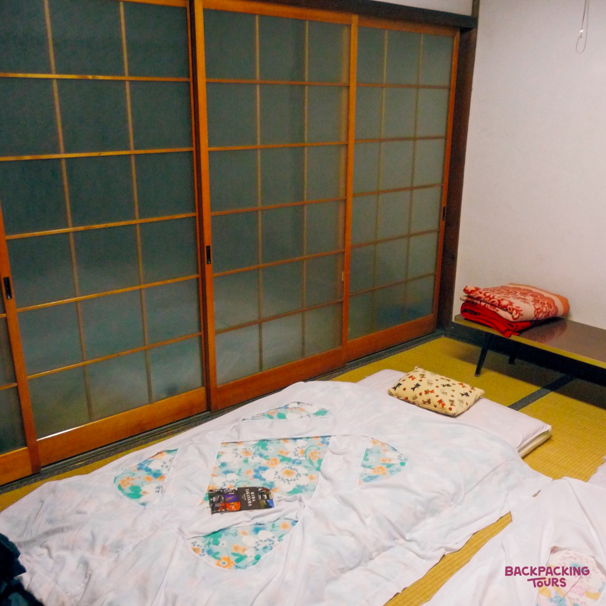 A cozy Japanese temple room in Takayama, with a futon bed on traditional tatami mats.