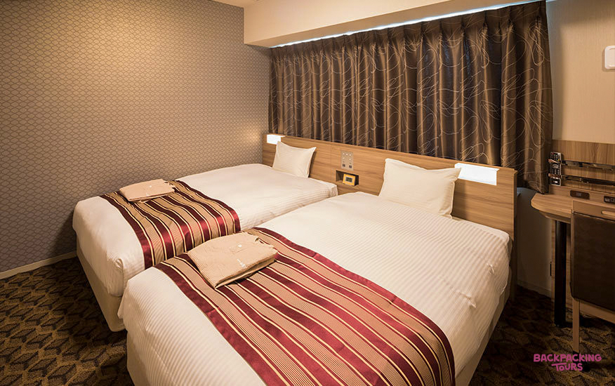 A clean and comfortable twin hotel room in Osaka, ready for a good night's rest.