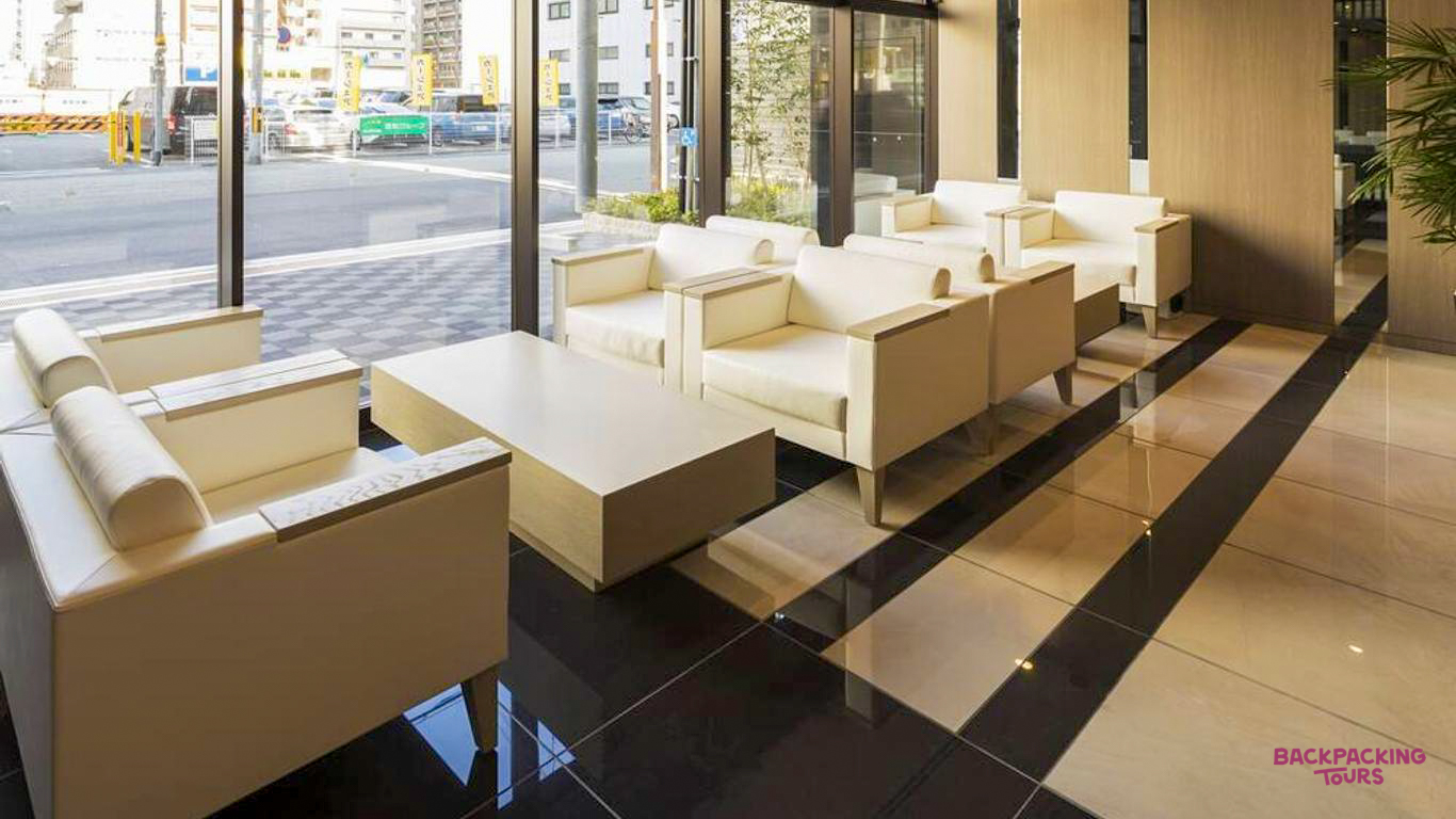 Spacious and bright hotel lobby in Osaka with modern white seating and large windows to the street.