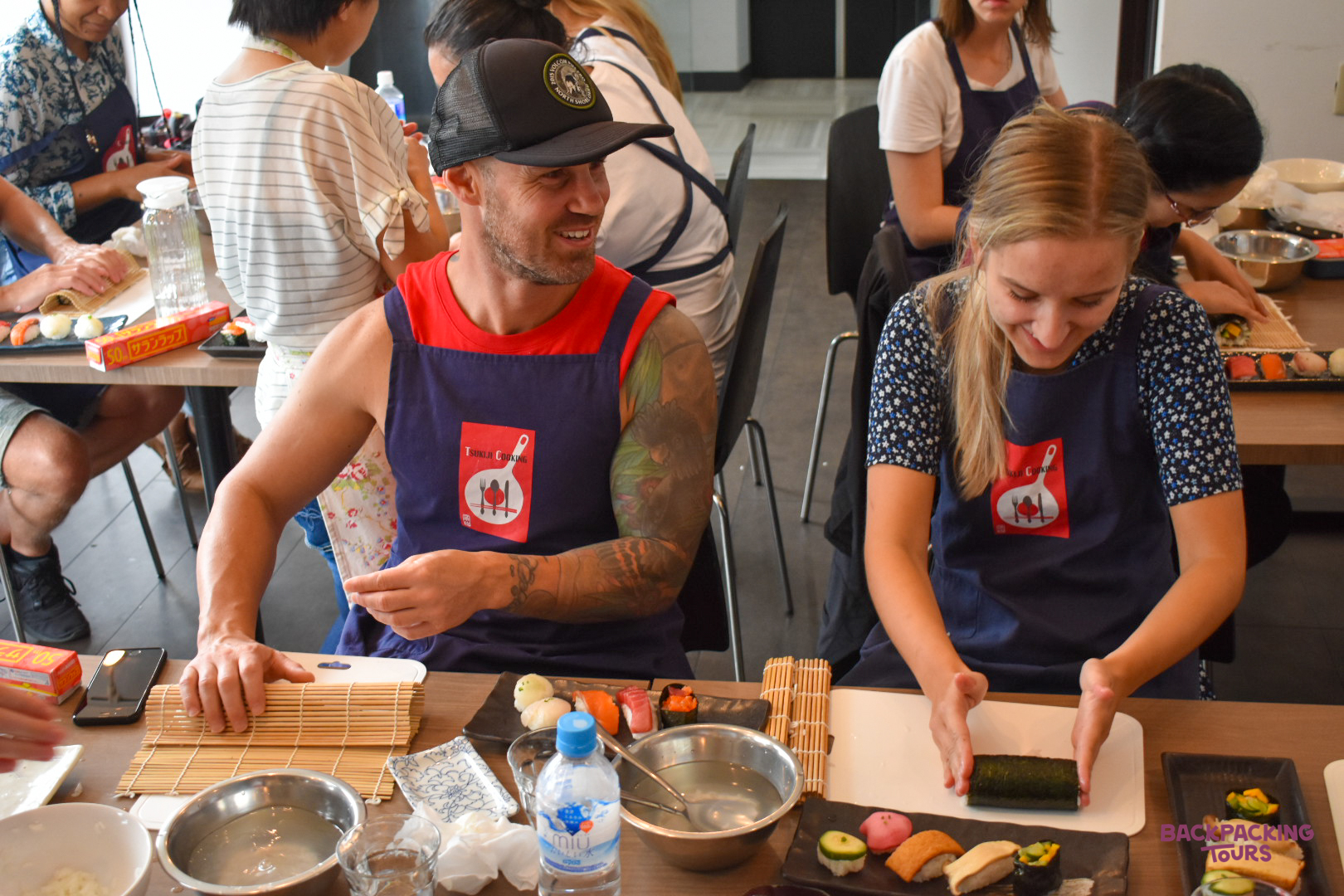 Travelers happily learn to hand-roll delicious sushi during a fun cooking class in Tokyo.