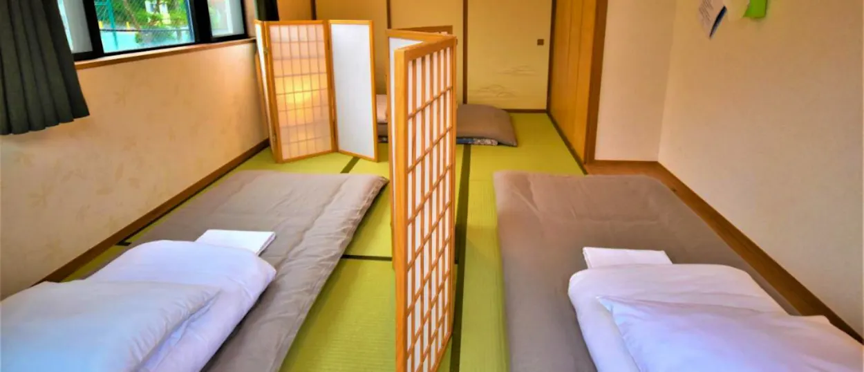 A traditional Japanese guesthouse room in Hakone with two futon beds and shoji screens.
