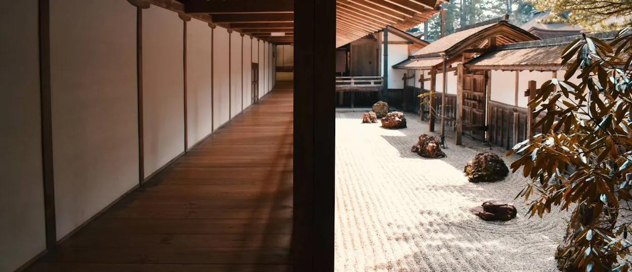 A traditional Japanese temple corridor runs alongside a peaceful raked zen garden in Koyasan.