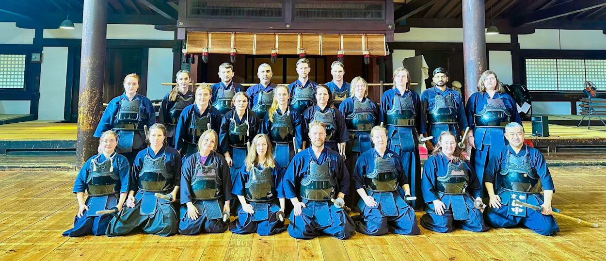 Travelers in Kendo uniforms and armor pose for a group photo after a Kendo class in Kyoto.