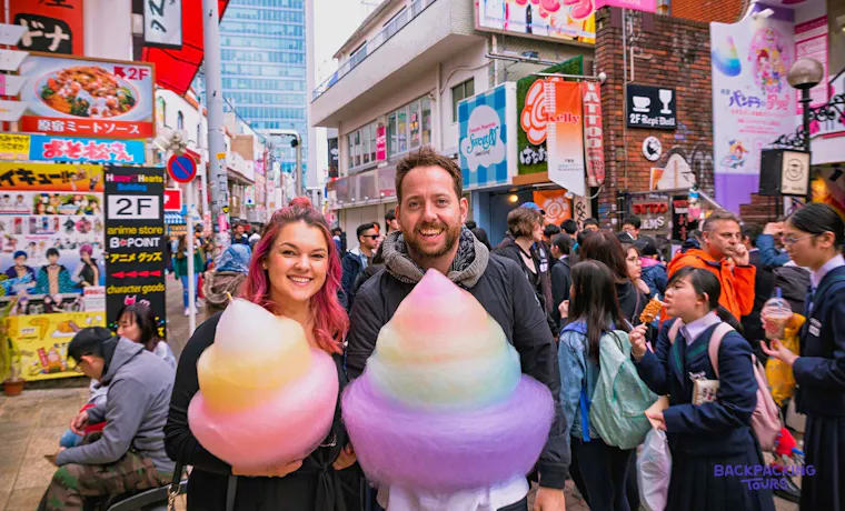Couple holding giant rainbow candy floss on Harajuku's Takeshita Street