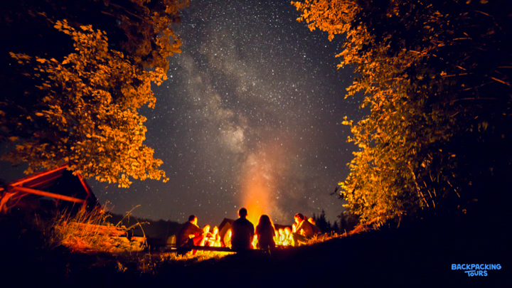 Backpackers enjoy a warm campfire under a spectacular starry night sky on Fraser Island.