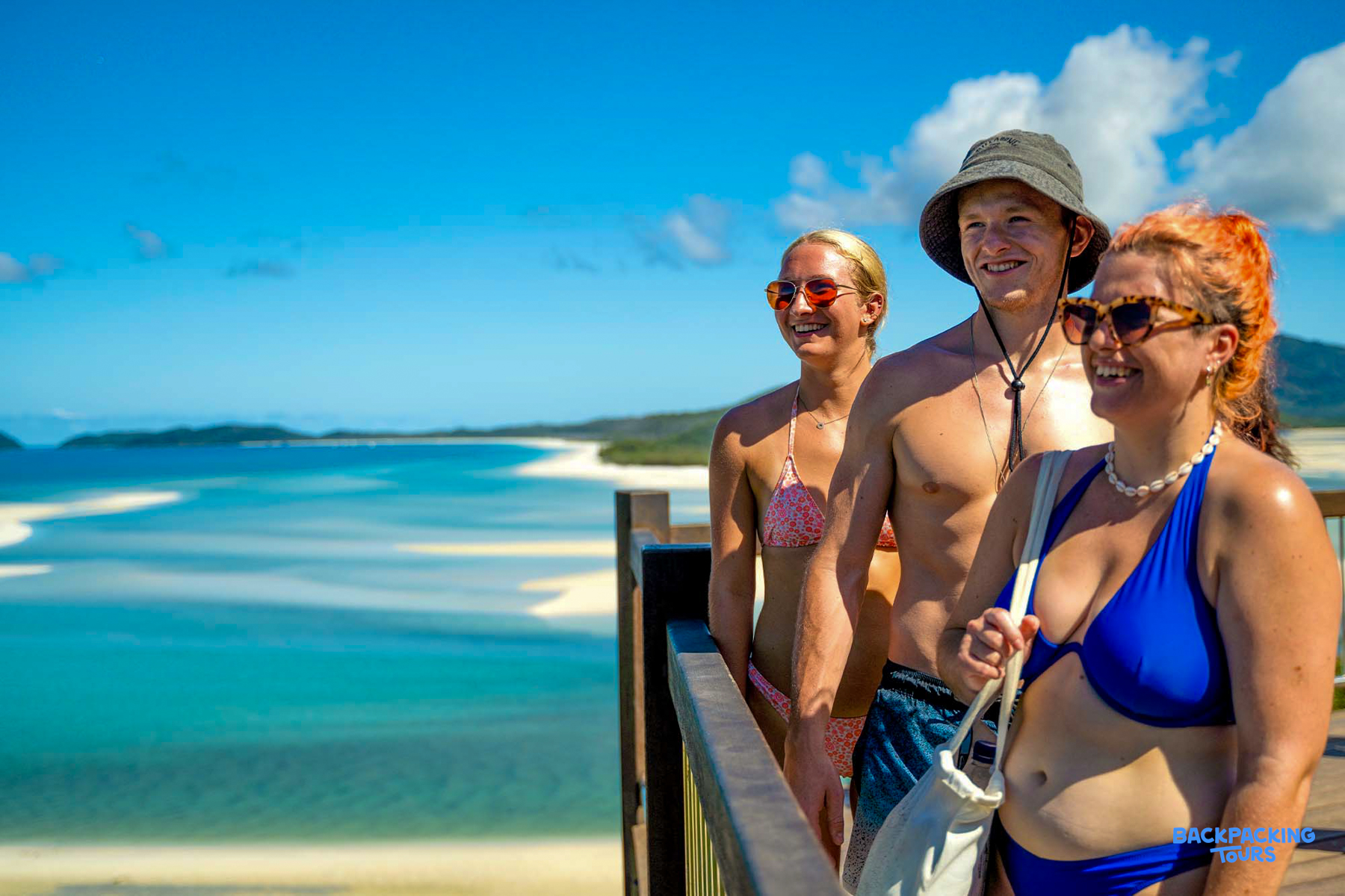 Happy travellers gaze at the stunning Whitehaven Beach and turquoise ocean in the Whitsundays.