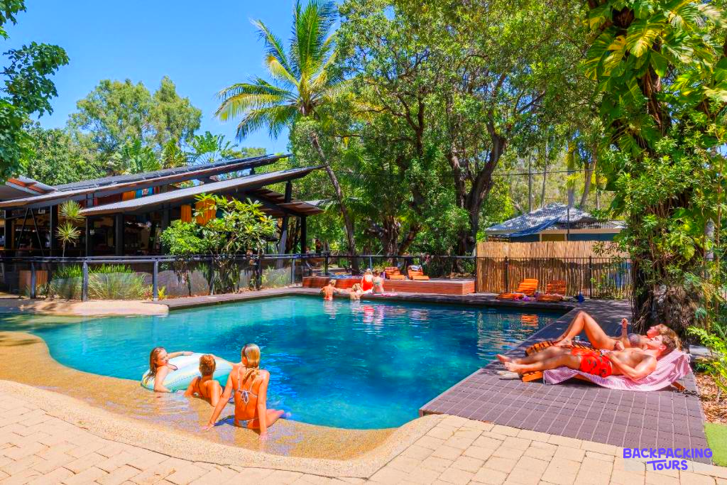 Guests relax by the vibrant blue pool at a tropical accommodation on Magnetic Island.