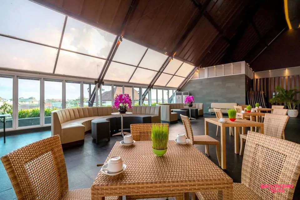A bright and airy rooftop restaurant with rattan furniture and panoramic views in Kuta, Bali.