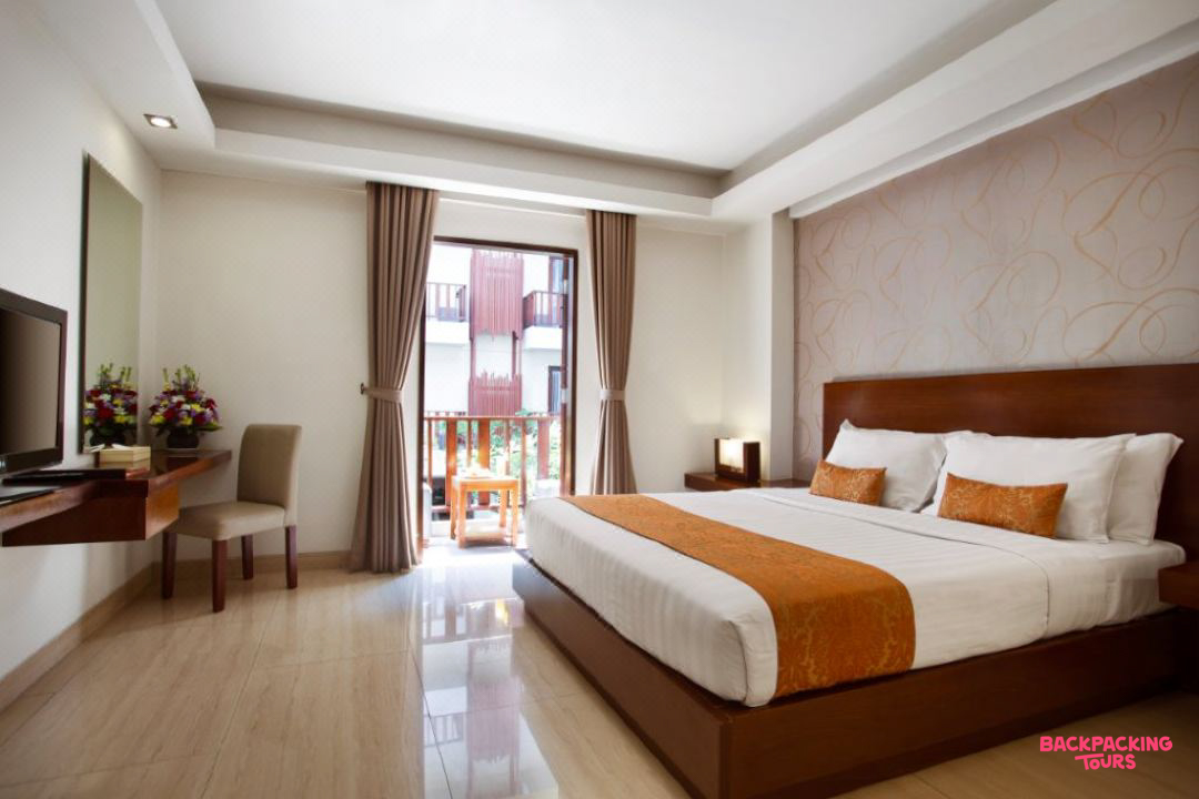 A modern and inviting hotel room with a large bed and a private balcony in Seminyak.