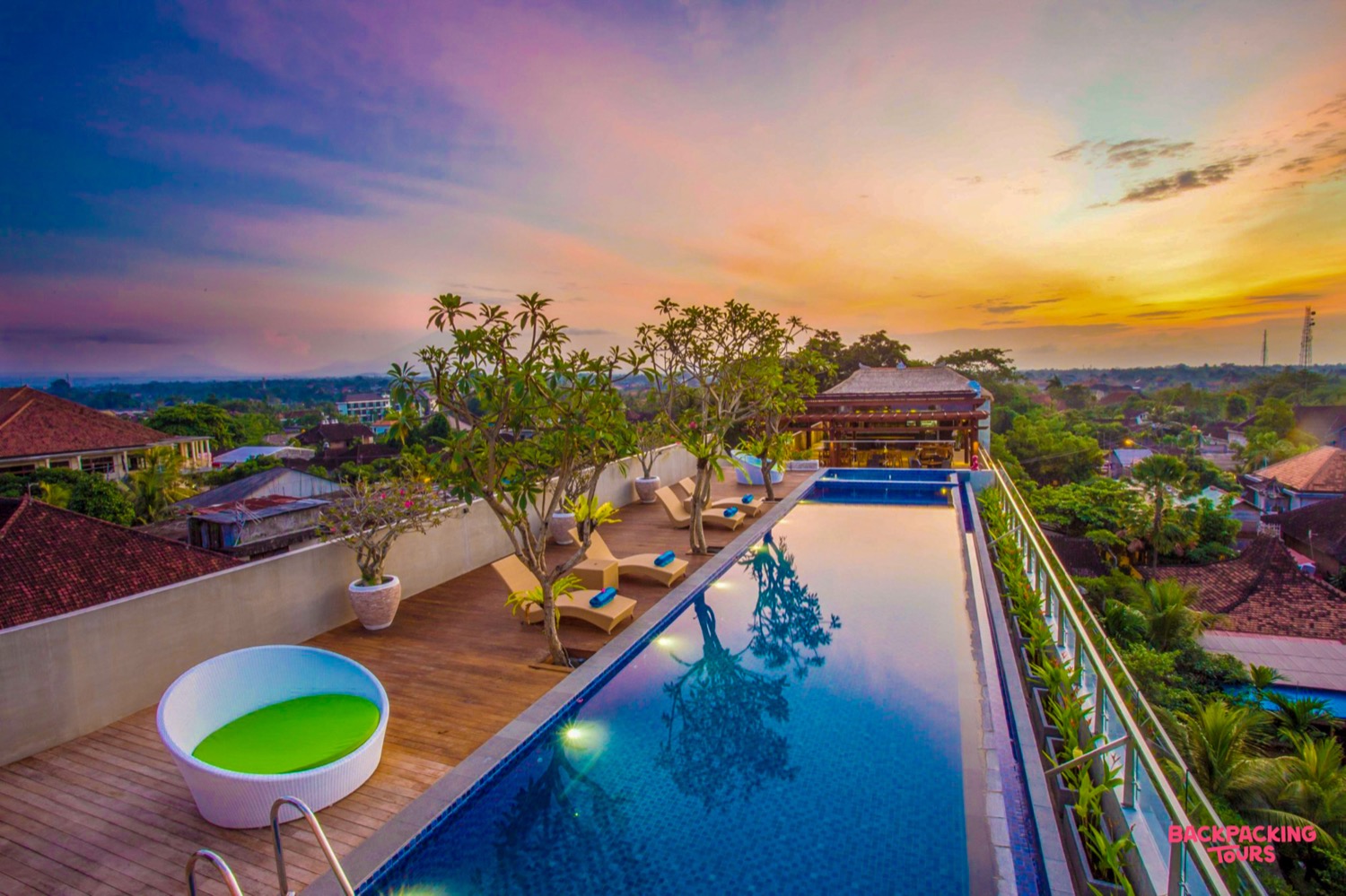 Stunning rooftop infinity pool overlooking Ubud at sunset, offering a serene and luxurious escape.