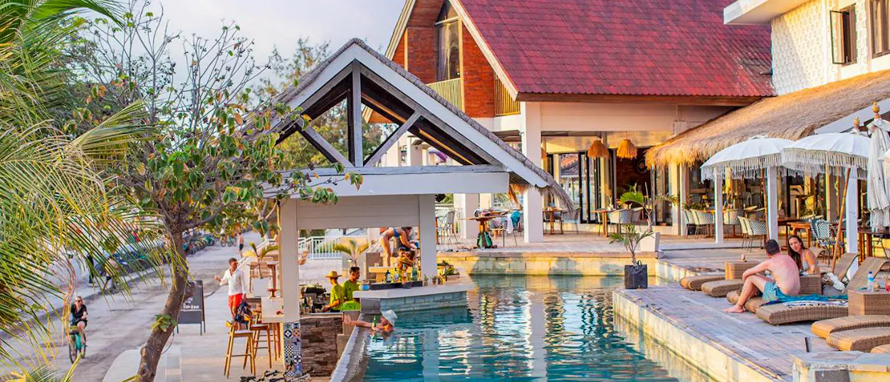 Travelers enjoy a sunny day by the pool with a swim-up bar on Gili Trawangan.