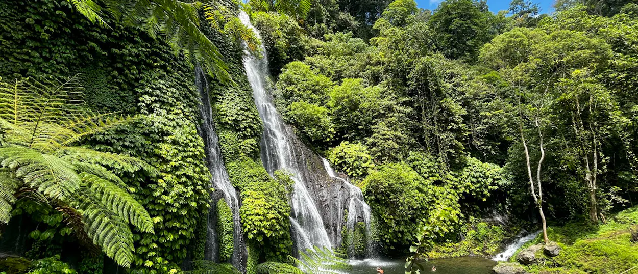 Stunning Banyumala Waterfalls in Ubud, Bali, surrounded by dense tropical jungle and a clear swimming pool.