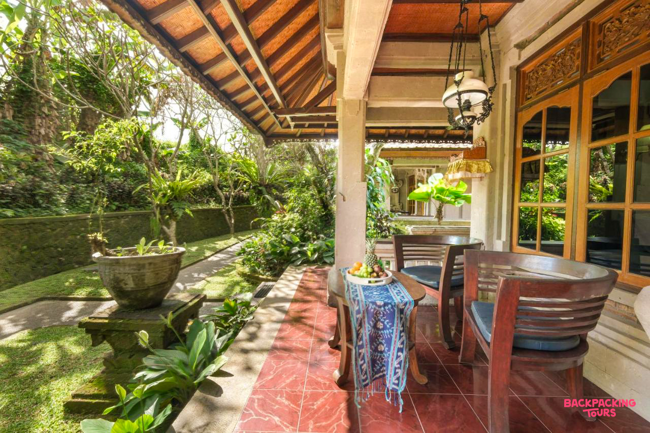 Relax on a peaceful outdoor patio surrounded by lush tropical gardens in Ubud, Bali.