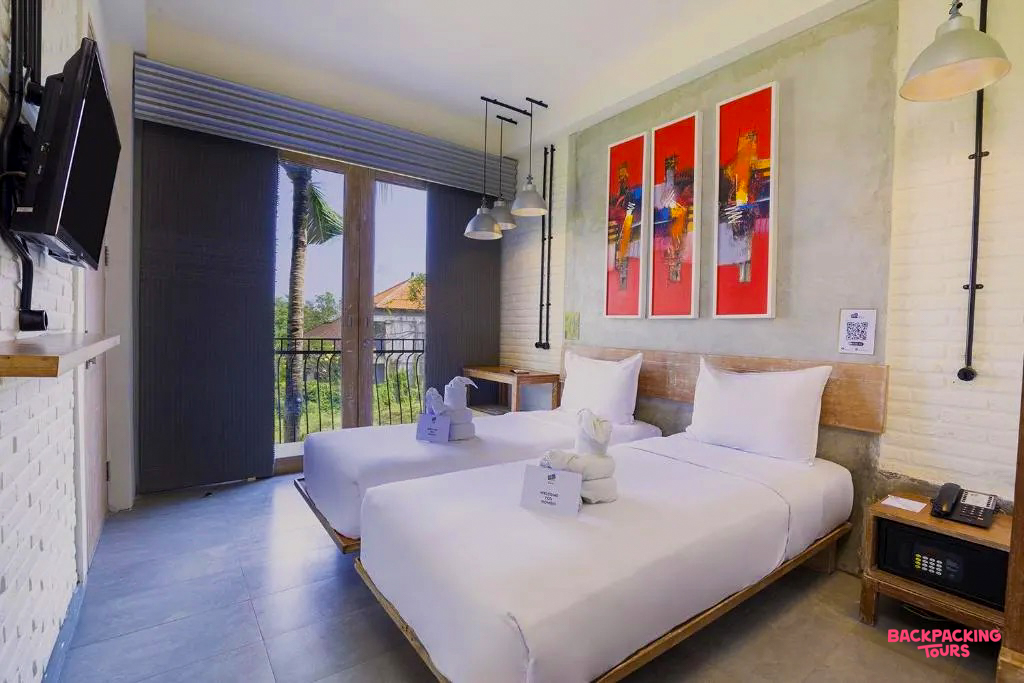 Inviting hotel room in Canggu with two single beds, crisp white linen, and a tropical view.