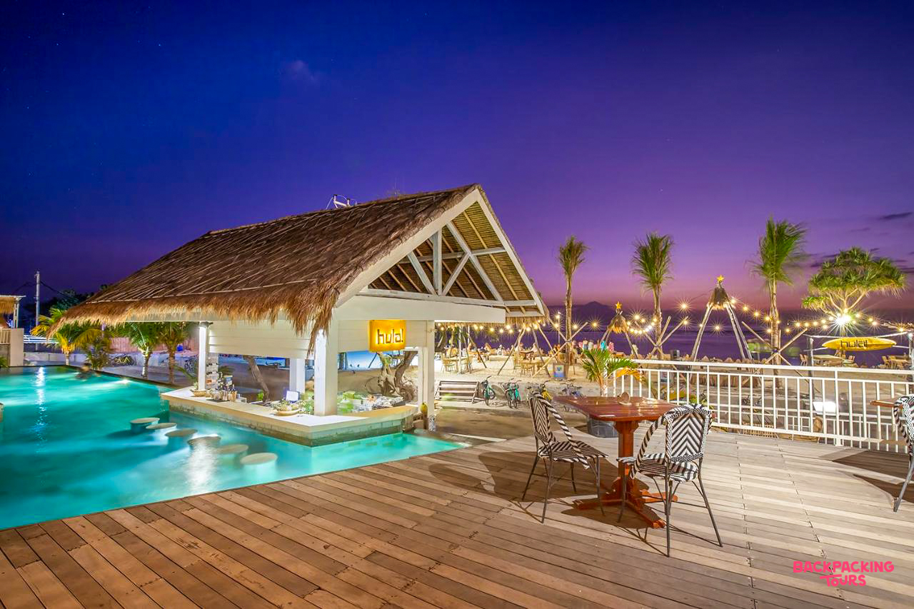 Evening at a tropical rooftop bar with a swim-up pool and ocean views on Gili Trawangan.