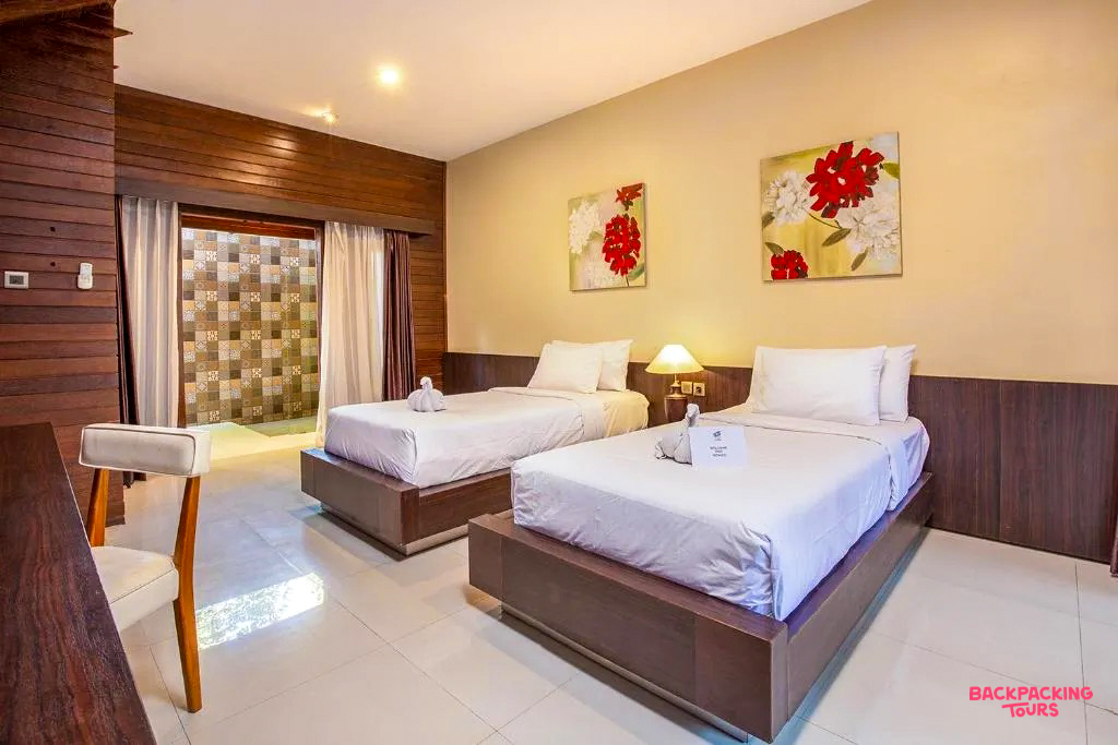 A bright twin room with two single beds, modern decor, and an open-air bathroom on Gili Trawangan.
