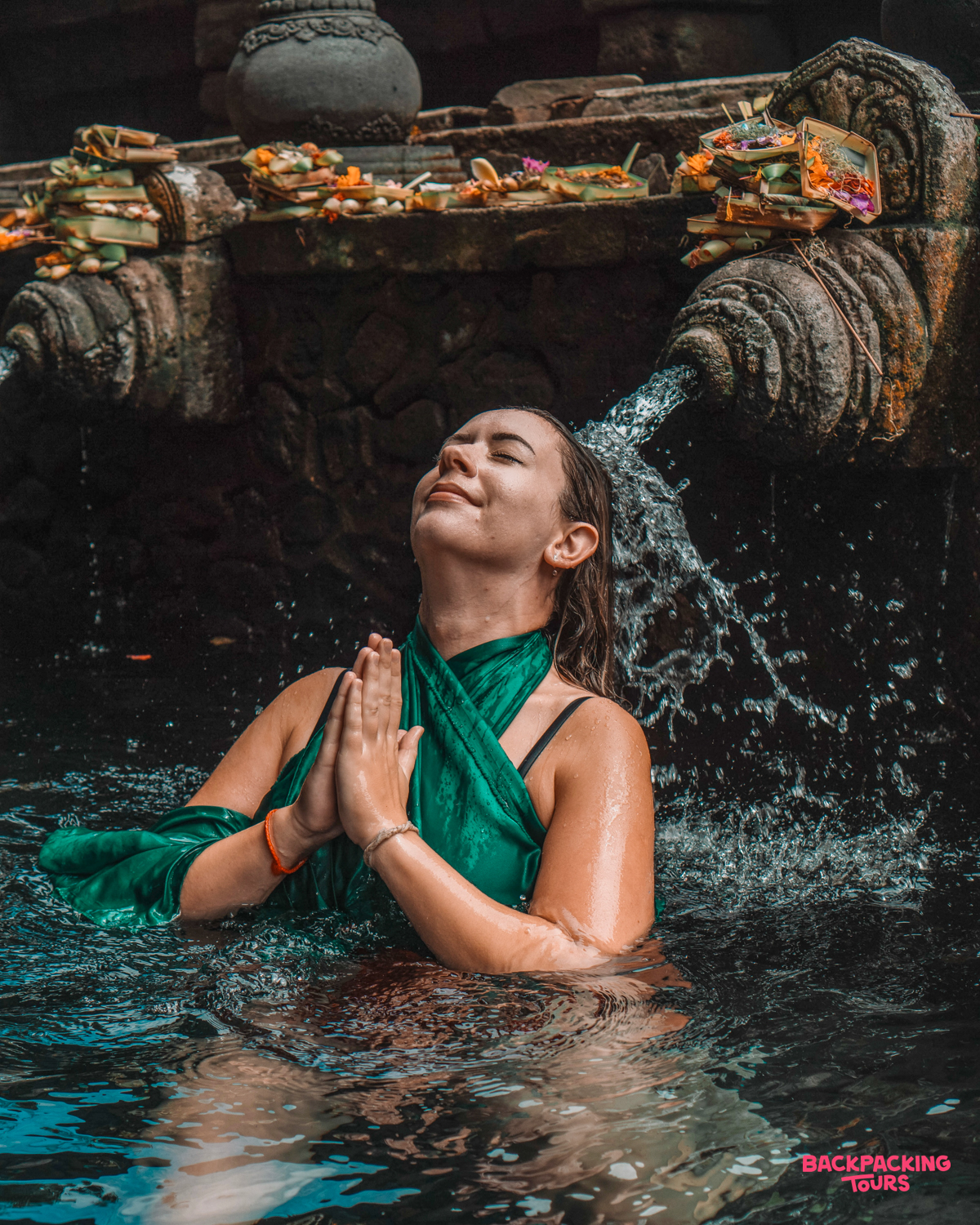 A woman participates in a traditional purification ritual at Tirta Empul water temple in Ubud, Bali.