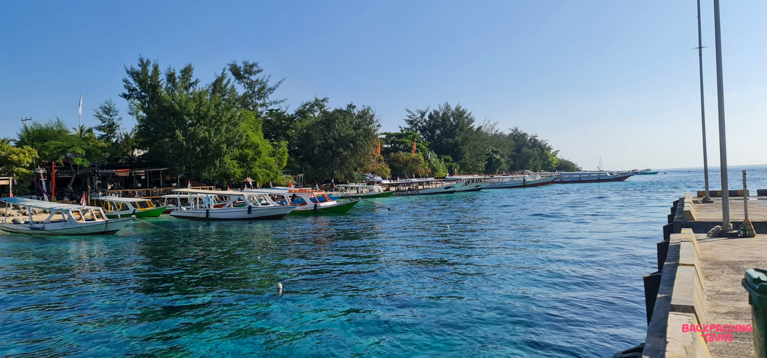 Boats docked along the clear turquoise waters of Pemuteran's peaceful tropical coastline.