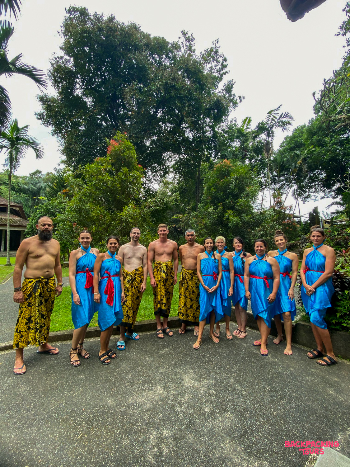 A group of travelers in traditional Balinese attire prepares for a purification ritual in Ubud.