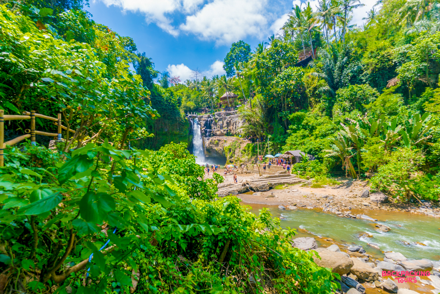 Travelers enjoy the powerful Tegenungan Waterfall surrounded by lush tropical jungle in Ubud, Bali.