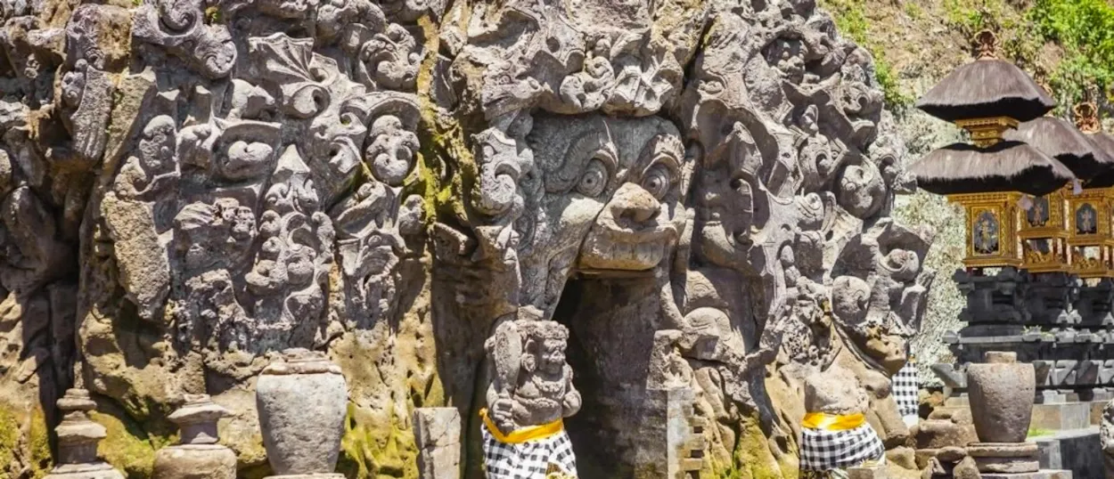 Detailed stone carvings of a demon mouth entrance at the ancient Goa Gajah temple in Bali.