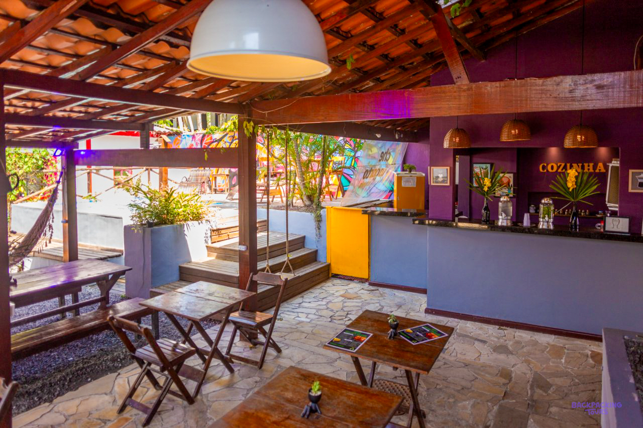 The colourful bar and lounge of the Paraty accommodation, with a hammock and wooden tables