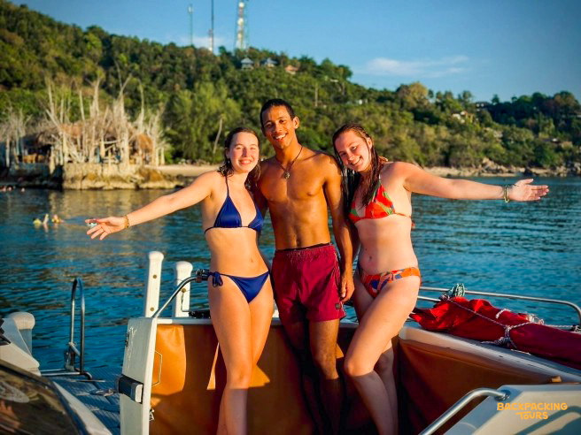 Three happy friends on a boat trip in the beautiful bay near Paraty, Brazil.