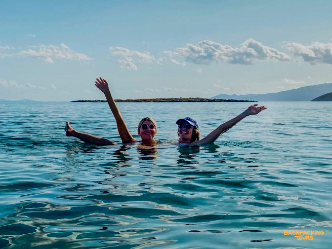 Smiling women enjoy a refreshing swim in the clear blue waters during an island-hopping trip near Paraty.