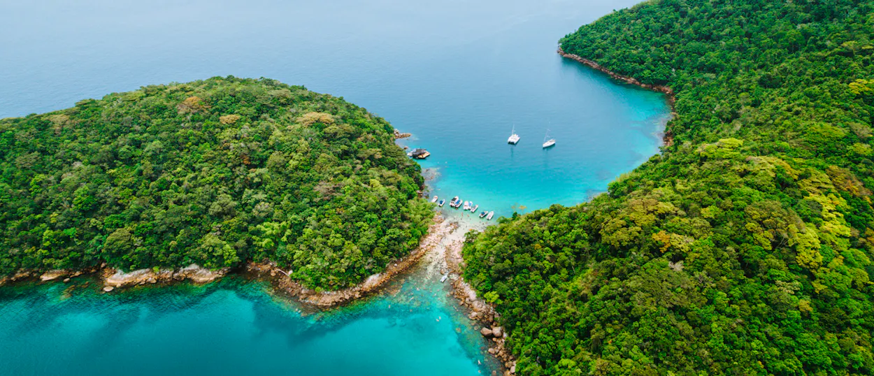 Aerial view of lush green islands and turquoise bays with boats anchored in Ilha Grande.