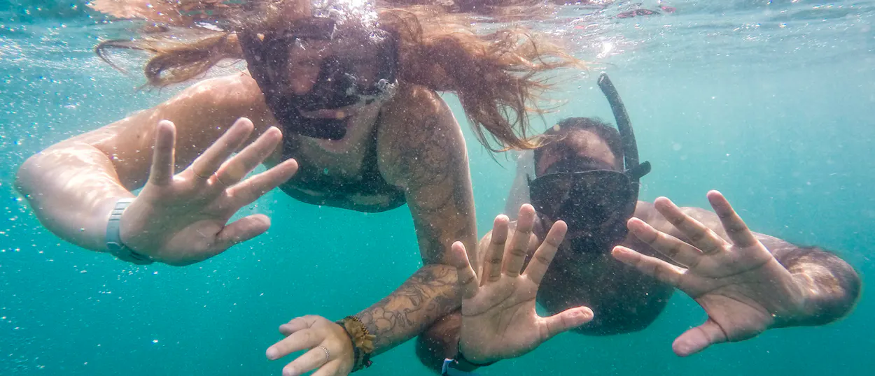 Happy friends snorkeling in the clear turquoise waters of Koh Rong, enjoying their adventure.