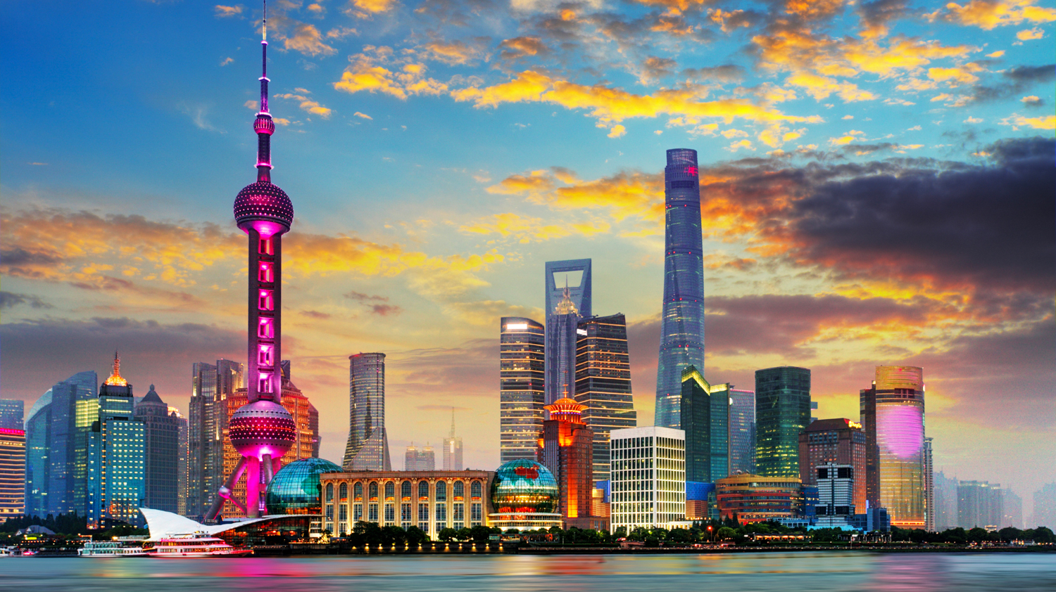 Vibrant Shanghai skyline at sunset, featuring the iconic Oriental Pearl TV Tower and modern skyscrapers.