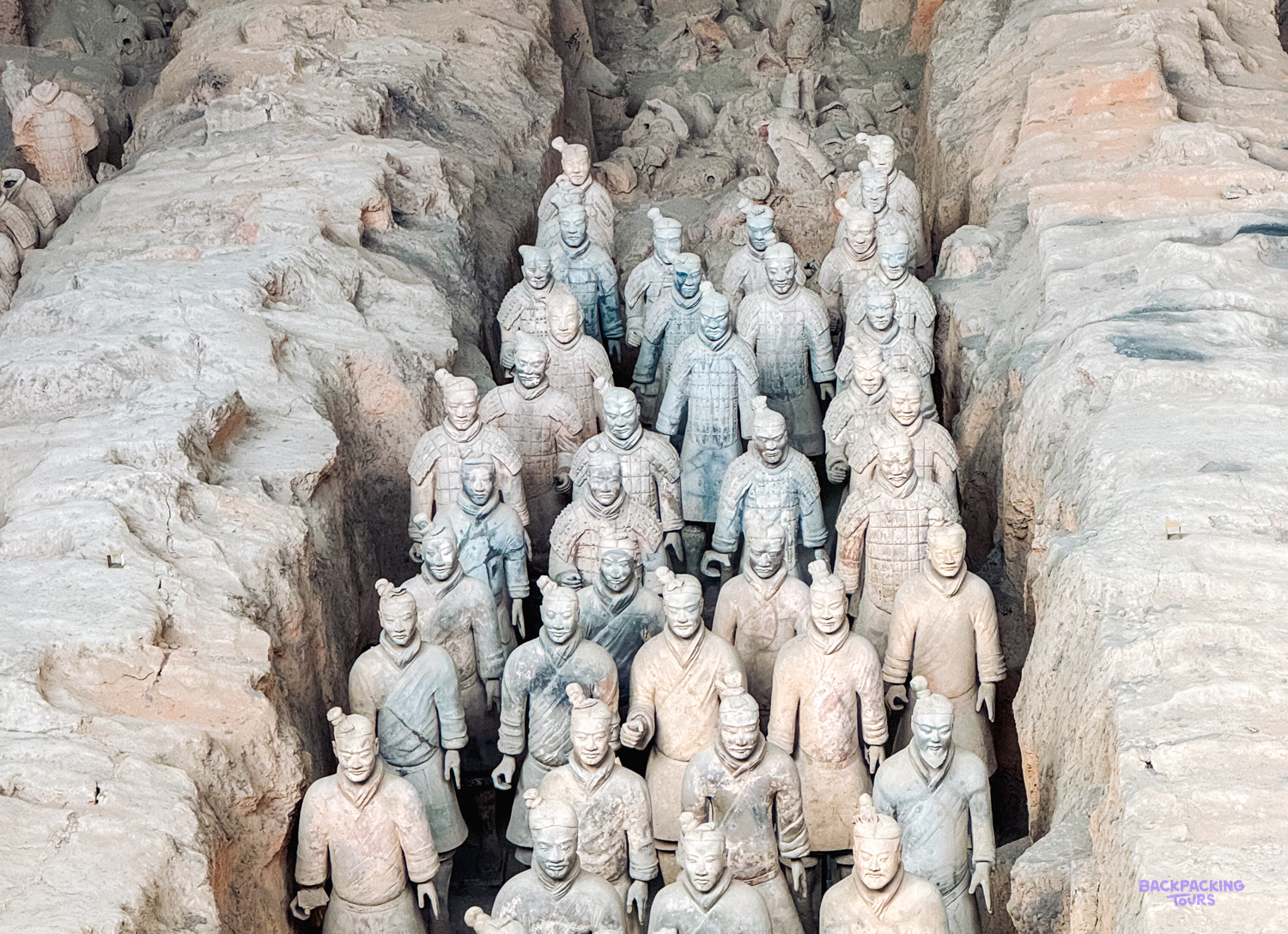 Ancient Terracotta Warriors stand in rows within their excavated pits in Xi'an, China.